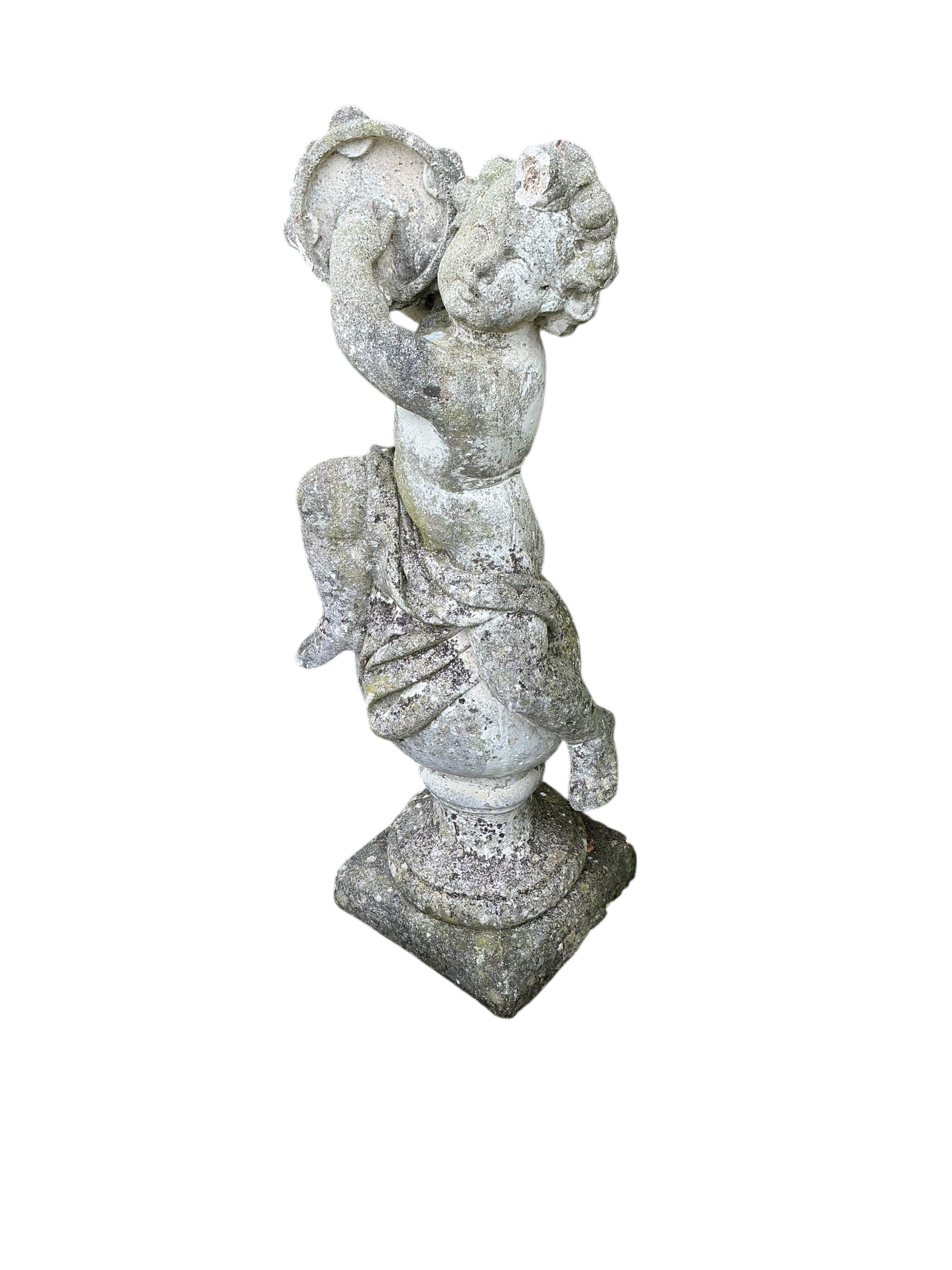 A reconstituted stone garden ornament of a cherub on ball, height 98cm